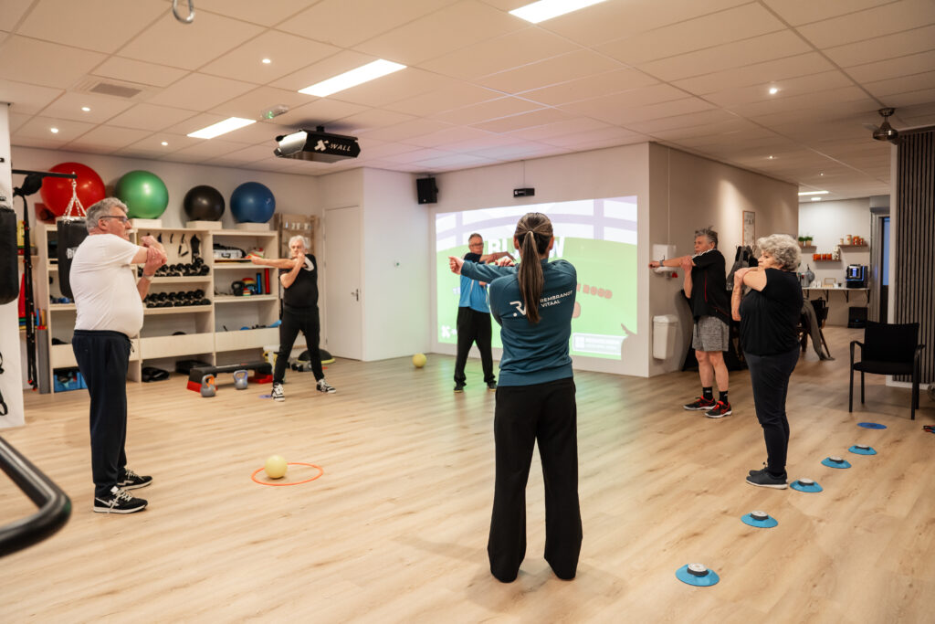 Een groep mensen staat in een kring en rekken hun armspier